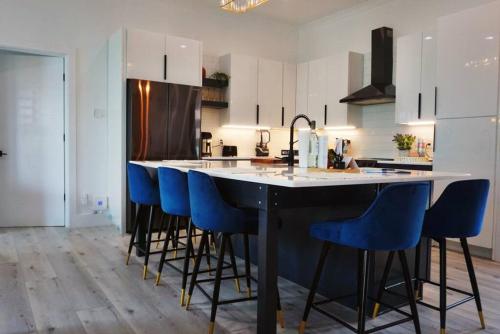 uma cozinha com uma grande ilha com bancos de bar azuis em Amazing New House - Waterfront Getaway + Boat Dock em Dandridge