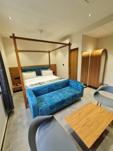 a bedroom with a large blue bed and a table at Hotel Nova Palm in Rajkot