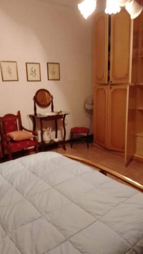a room with a bed and chairs and a mirror at Casa a Sorso per le tue vacanza in Sorso