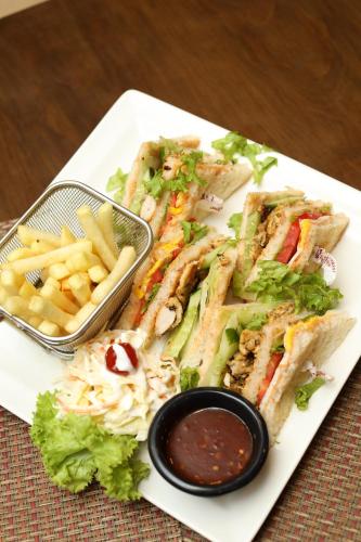 a white plate with two sandwiches and french fries at Magnum Inn in Lahore