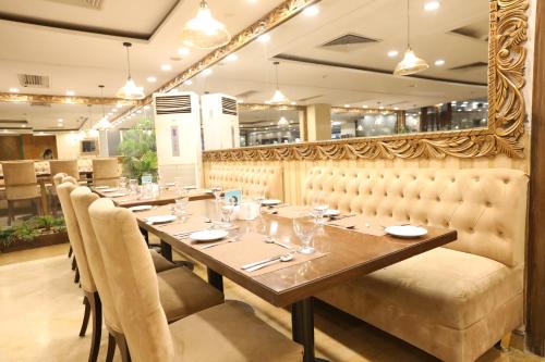 a dining room with a long table and chairs at Magnum Inn in Lahore