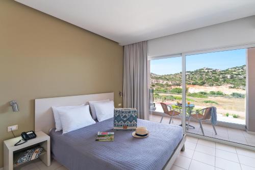 a hotel room with a bed and a balcony at Cathrin Hotel in Faliraki