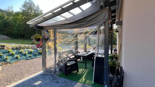 烏斯特龍的住宿－Domek Pierwiosnek Ustroń，房屋内带桌子和遮阳篷的庭院