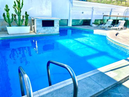 a large swimming pool with a blue pool at Loft Prainha Vista Mar in Arraial do Cabo