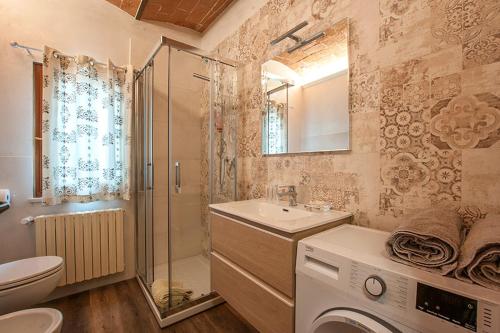 y baño con lavabo y lavadora. en Affittacamere Il Bastione 27 en Volterra