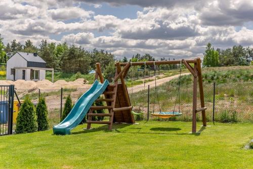 a playground with a slide in the grass at Kaszubska Lawenda Żuromino, Domek nr 3 in Żuromino