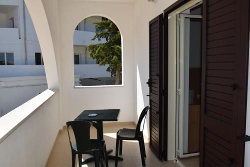 a table and chairs in a balcony with a window at Hotel Maggiore in Vieste
