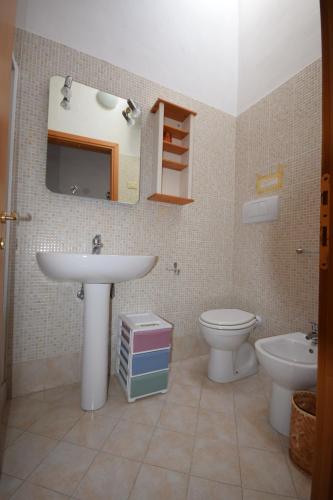a bathroom with a sink and a toilet and a mirror at Mansarda tra Cielo e Mare in Scarlino