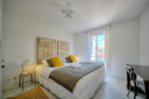 sypialnia z dużym łóżkiem z żółtymi poduszkami w obiekcie IMMOGROOM - Duplex with air conditioner - 5 min from the beach - Suquet w Cannes