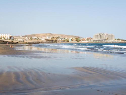 a beach with the ocean and buildings in the background at Live Inglaterra Medano Beach in El M&eacute;dano