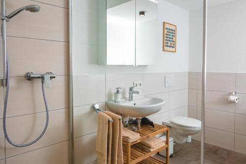 a bathroom with a sink and a toilet and a shower at Ferienwohnung`Akazie` mit Terrasse auf dem Bodanrück in Radolfzell am Bodensee