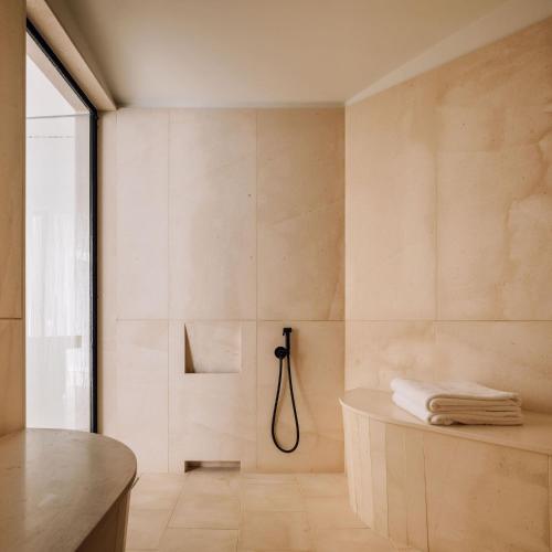a bathroom with a shower with a tub at Aethos Ericeira in Ericeira