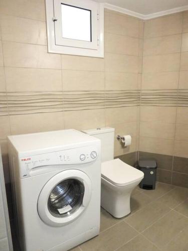 a bathroom with a washing machine and a toilet at Serene, slow living house in Orné