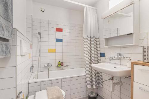 a white bathroom with a sink and a bath tub at Lake View See & Bergsicht free parking in Kreuzlingen