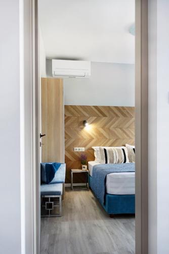 a bedroom with a blue bed and a chair at Okean Apartments in Ierissos