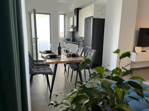 cocina con mesa de madera y sillas en una habitación en Solen Apartments en Durrës