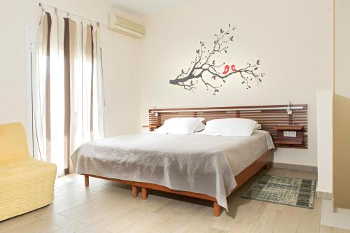 a bedroom with a bed with a branch on the wall at Mary's Maisonette in Kos