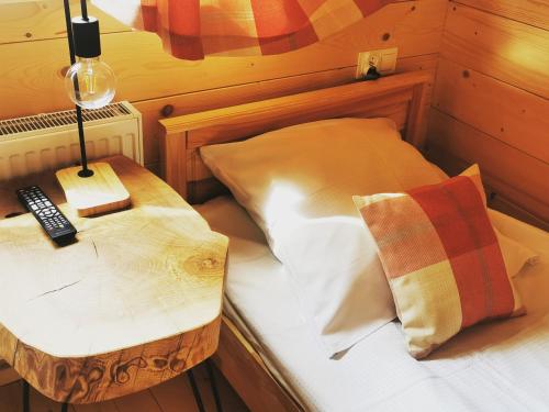 a bedroom with a bed with a table and a remote control at Heidi in Zakopane