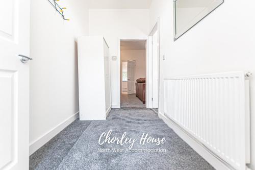 un pasillo de una casa con paredes blancas y alfombra en Chorley Contractor Accommodation en Chorley