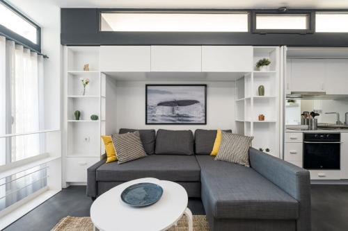 ein Wohnzimmer mit einem Sofa und einem Tisch in der Unterkunft Newly Designed Central Modern Smart Duplex! #143 in Istanbul