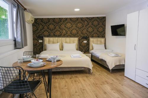 Un dormitorio con 2 camas y una mesa con platos. en Taksim Neo Pera Suites, en Estambul