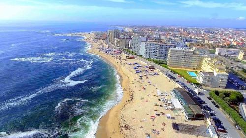 plaża z tłumem ludzi i ocean w obiekcie Casa Jardins da Praia w mieście Póvoa de Varzim