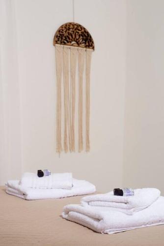 a room with white towels and a chandelier at G&K House Garden in Messini