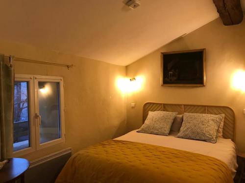 1 dormitorio con 1 cama con 2 almohadas y ventana en L’OBSERVATOIRE en Saint-Michel-lʼObservatoire