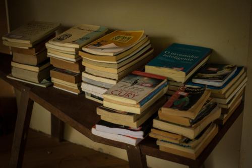 un montón de libros sentados en una mesa en Albacora Eco Residence en Imbassai