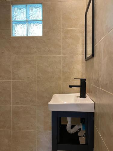 a bathroom with a white sink and a window at Mythai Guesthouse in Chaloklum