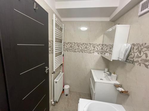 La salle de bains est pourvue de toilettes blanches et d'une porte noire. dans l'établissement BUCHAREST APARTMENTS 3 camere, à Bucarest
