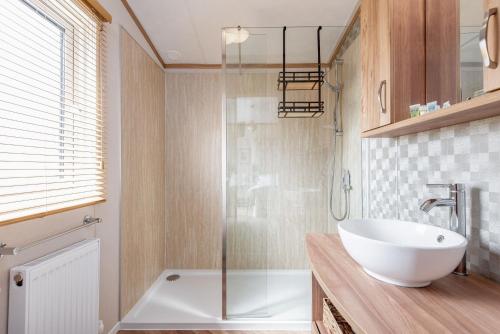 a bathroom with a sink and a glass shower at Stewarts Resort Lodge 76 in St Andrews
