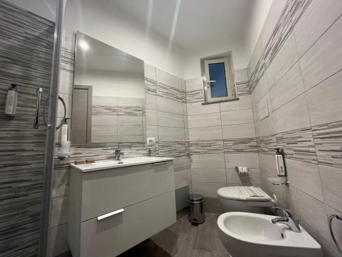 a white bathroom with a sink and a toilet at La Casba in Paola