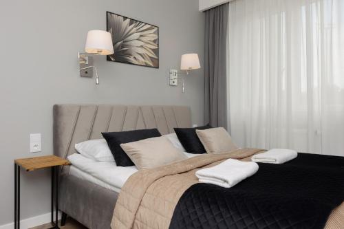 Stunning Family Apartment Ursynów with Parking & Balcony by Noclegi Renters في وارسو: غرفة نوم بها سرير عليه منشفتان