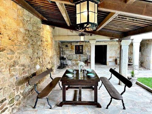 a wooden table and chairs on a stone patio at Holibai, O Canizo, Retroceder En La Historia Y El Tiempo in Baiona