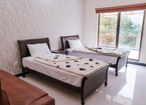 A bed or beds in a room at Resort One Murree