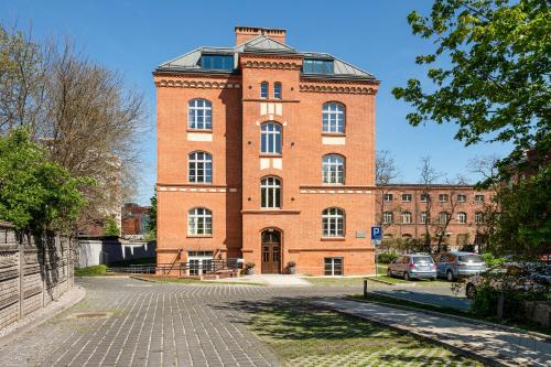 un grand bâtiment en briques rouges avec une tour d'horloge dans l'établissement Waterlane Vintage - Fitness & Gym by Downtown Apartments, à Gdańsk