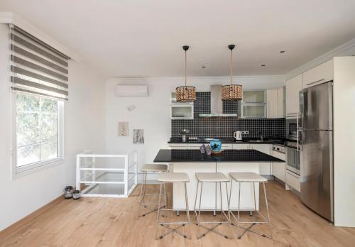a kitchen with white counters and a refrigerator and stools at Gorgeous Bright Private 2bd Sea View Home! #24 in Istanbul