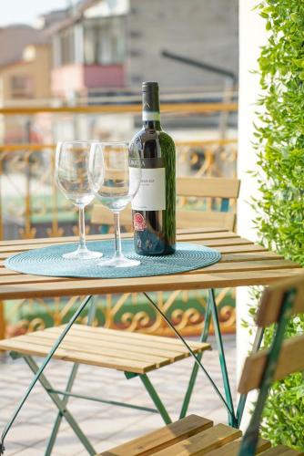 a bottle of wine sitting on a table with two glasses at Ninfea Apartment Superior in Vico Equense