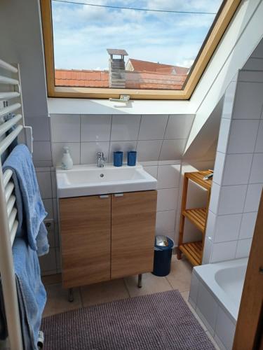 ein Badezimmer mit einem Waschbecken und einem Dachfenster in der Unterkunft Giebelzimmer mit Weinbergblick in Stetten
