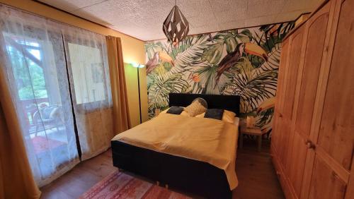 Schlafzimmer mit einem Bett mit Wandbild in der Unterkunft Villa Blu in Sankt Kanzian am Klopeiner See