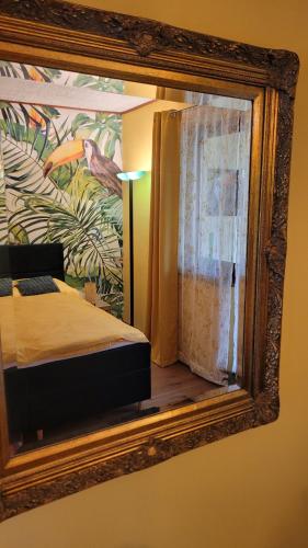 a mirror reflecting a bedroom with a bed and a painting at Villa Blu in Sankt Kanzian