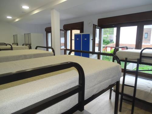 a room with four bunk beds in a building at Albergue Roma in Pola de Lena