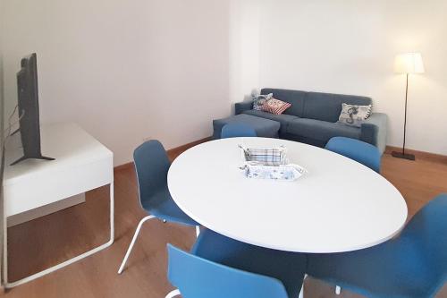 a living room with a white table and blue chairs at Casa Brezza marina in Marina di Campo