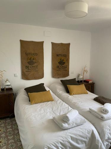 two beds in a room with bags on the wall at Casa Fulanita in Cabezuela