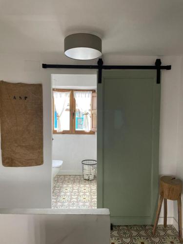 a door to a bathroom with a toilet and a window at Casa Fulanita in Cabezuela