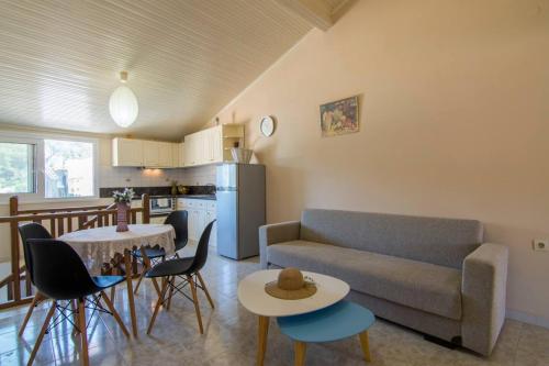 uma sala de estar com um sofá, uma mesa e cadeiras em Paxos In Square (Apartment Amfitriti) em Gaios