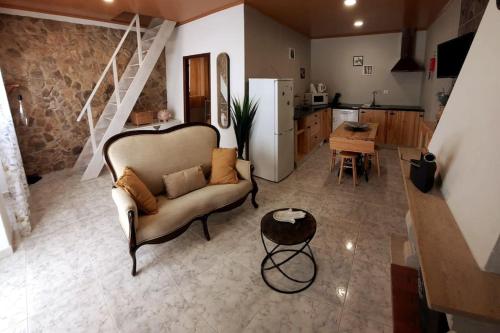 salon z kanapą i kuchnią w obiekcie Casa Emília & Alda w mieście Juncal