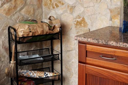 a kitchen with a counter and a shelf with a sink at Casa Emília & Alda in Juncal