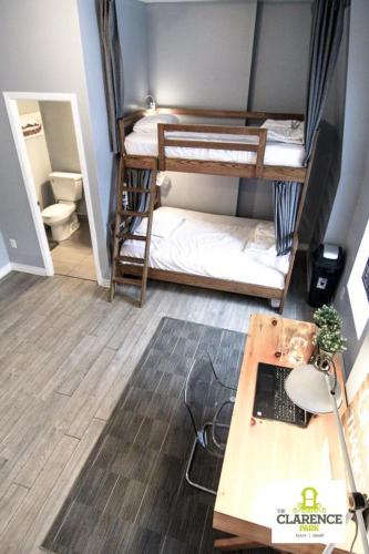 a small room with two bunk beds and a desk at The Clarence Park in Toronto